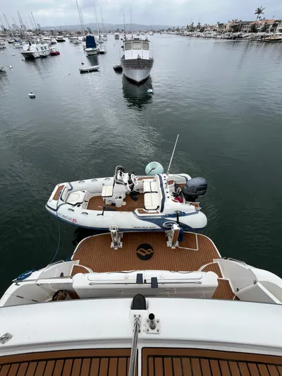 Our Time Yacht Photos Pics 2001 Bayliner 5788 Pilot House Motoryacht with tender in a marina setting.