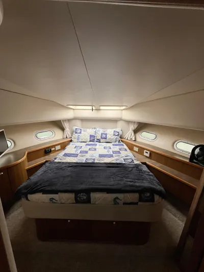 Our Time Yacht Photos Pics Luxurious bedroom in 2001 Bayliner 5788 Pilot House Motoryacht with cozy bedding and porthole windows.