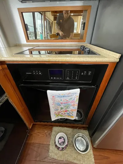Our Time Yacht Photos Pics 2001 Bayliner 5788 Pilot House Motoryacht kitchen with stove, oven, and pet bowls.