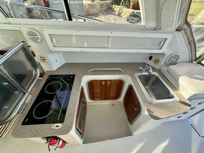 Sassy Cat Yacht Photos Pics Compact kitchen area in a 2009 Glacier Bay 3080 boat with stove and sink.
