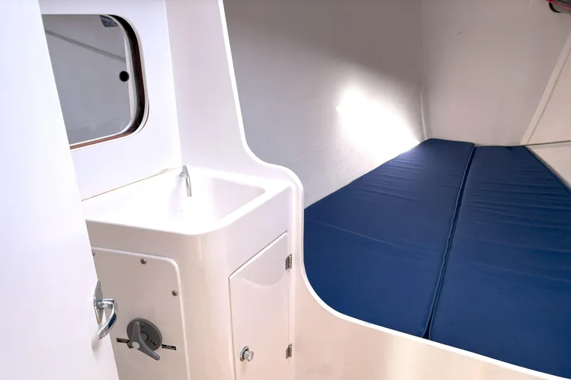 Ripple Yacht Photos Pics 2015 J Boats J 111 interior with sink and blue cushioned berth.