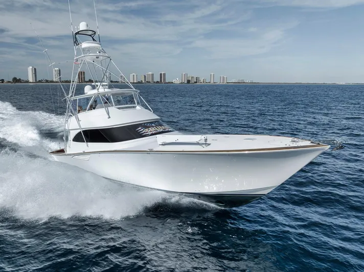 Life Is Good Yacht Photos Pics 2015 Viking 70 Convertible yacht cruising on open water with city skyline in background.