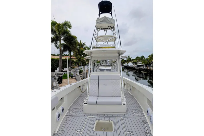Hazard Pay Yacht Photos Pics 2017 SeaVee 390Z boat with tower, docked near palm trees and canal.