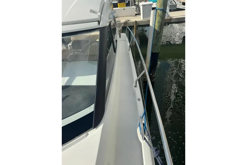 Lololand Yacht Photos Pics 2018 Jeanneau Leader 36 yacht docked at marina, side view with railing.
