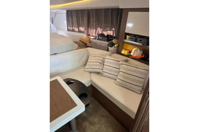 Lololand Yacht Photos Pics Interior of 2018 Jeanneau Leader 36 yacht with cozy seating and striped cushions.