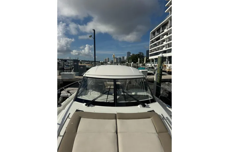 Lololand Yacht Photos Pics 2018 Jeanneau Leader 36 yacht docked at marina, city skyline in background.