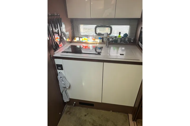 Lololand Yacht Photos Pics Compact kitchen area in a 2018 Jeanneau Leader 36 yacht, featuring a sink and stove.
