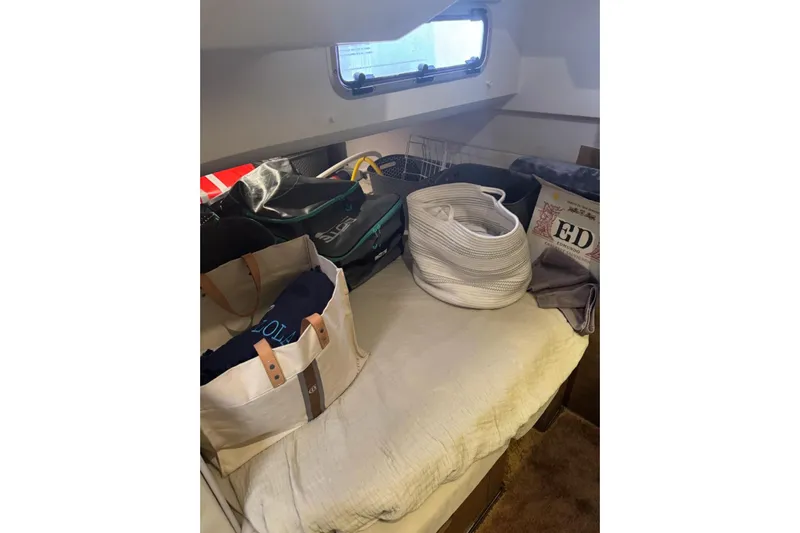 Lololand Yacht Photos Pics Interior cabin of 2018 Jeanneau Leader 36 with bags and accessories on bed.