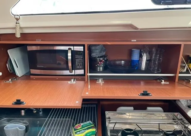  Yacht Photos Pics Interior view of 2018 Beneteau Oceanis 41.1 kitchen with microwave and storage cabinets.