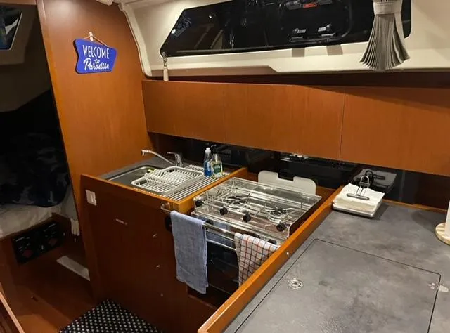  Yacht Photos Pics Interior of 2018 Beneteau Oceanis 41.1 yacht kitchen with wooden cabinetry and modern amenities.