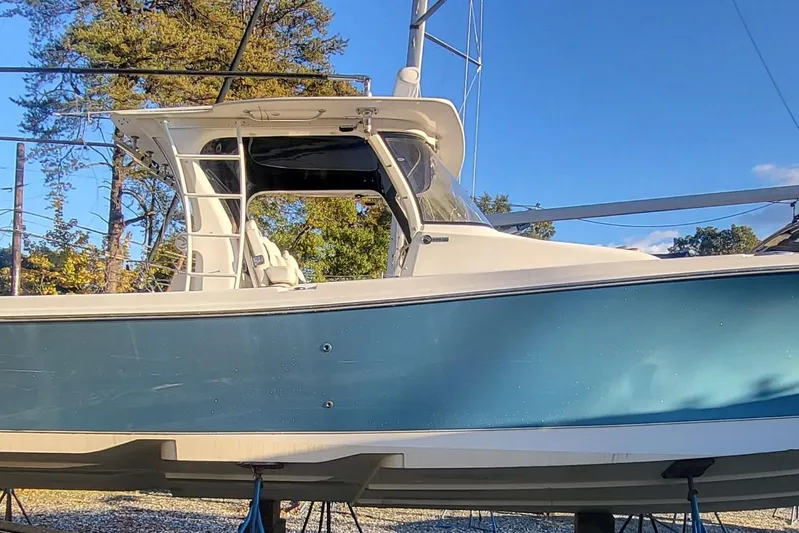  Yacht Photos Pics 2018 Edgewater 370CC boat with blue hull, docked outdoors under clear sky.