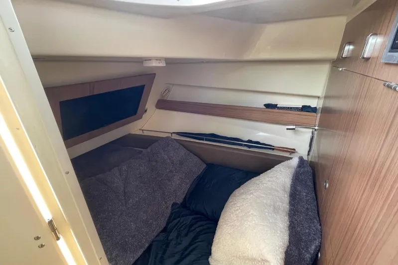  Yacht Photos Pics 2022 Chris-Craft Calypso 35 cabin interior with cozy bedding and wooden accents.