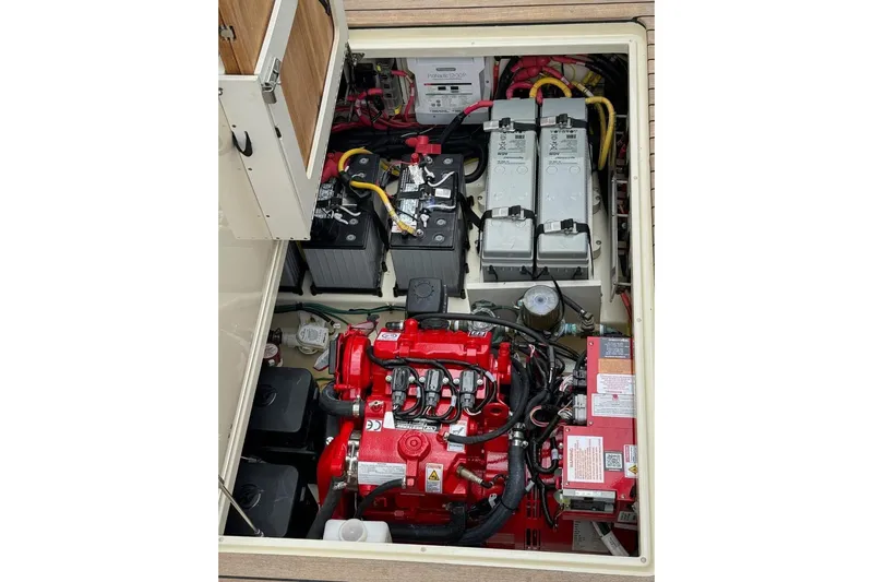  Yacht Photos Pics Engine compartment of 2022 Chris-Craft Calypso 35, showcasing batteries and red engine components.