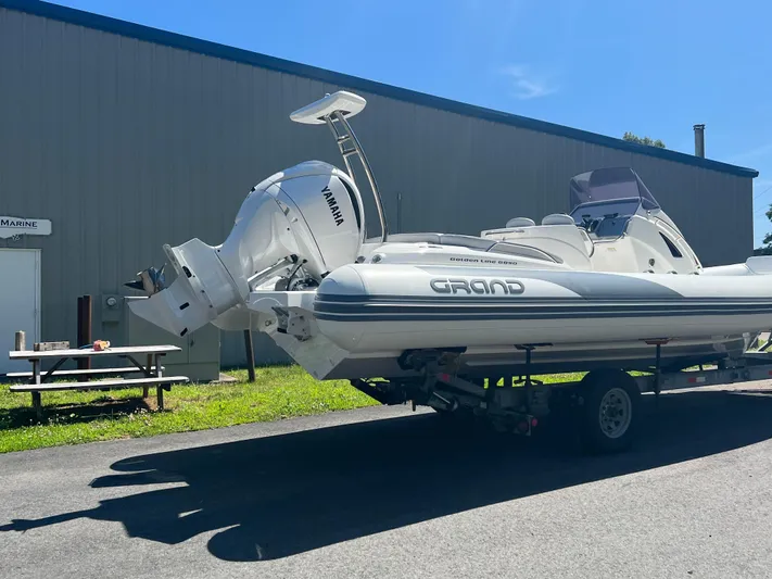 Yacht Photos Pics 2024 Grand Goldenline 850 boat on trailer, parked outdoors.
