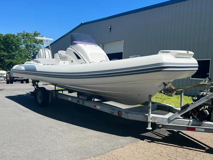  Yacht Photos Pics 2024 Grand Goldenline 850 boat on trailer, parked outside a warehouse.