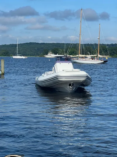  Yacht Photos Pics 2024 Grand Goldenline 850 boat on a serene lake with sailboats in the background.