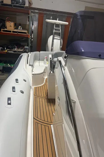  Yacht Photos Pics 2024 Grand Goldenline 850 boat with sleek design and wooden deck in a garage setting.