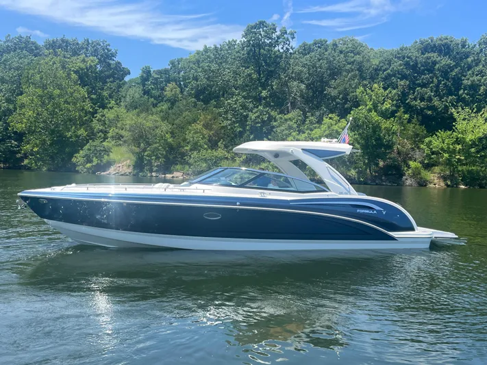  Yacht Photos Pics 2023 Formula 350 Crossover Bowrider I/O on a serene lake with lush greenery.