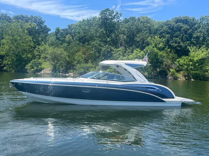  Yacht Photos Pics 2023 Formula 350 Crossover Bowrider I/O on a serene lake with lush greenery.