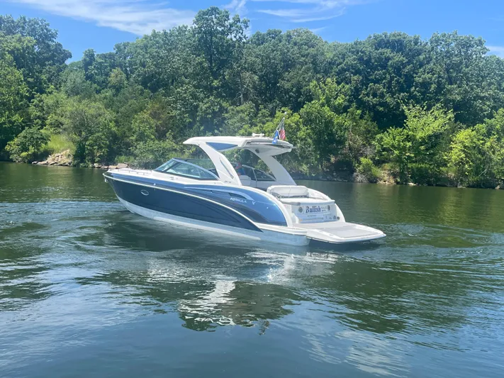  Yacht Photos Pics 2023 Formula 350 Crossover Bowrider I/O cruising on a serene lake with lush greenery.