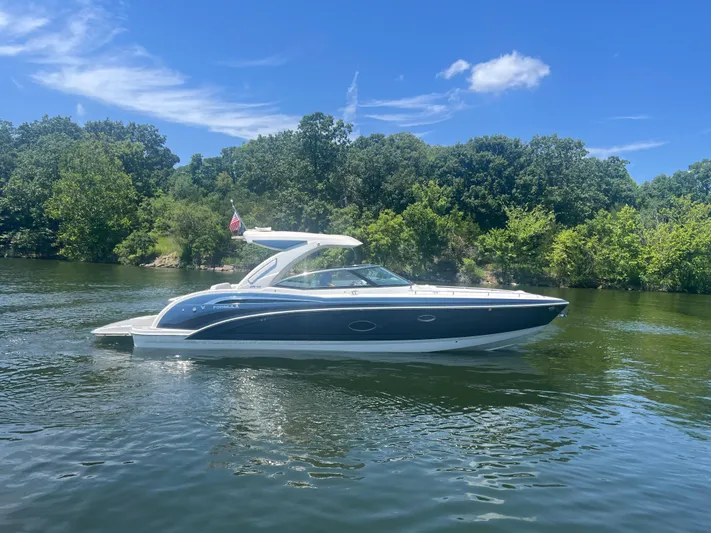  Yacht Photos Pics 2023 Formula 350 Crossover Bowrider I/O on a serene lake with lush greenery.