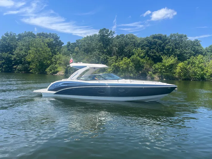  Yacht Photos Pics 2023 Formula 350 Crossover Bowrider I/O on a serene lake with lush greenery.