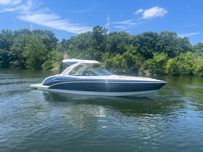  Yacht Photos Pics 2023 Formula 350 Crossover Bowrider I/O on a scenic lake under a clear blue sky.