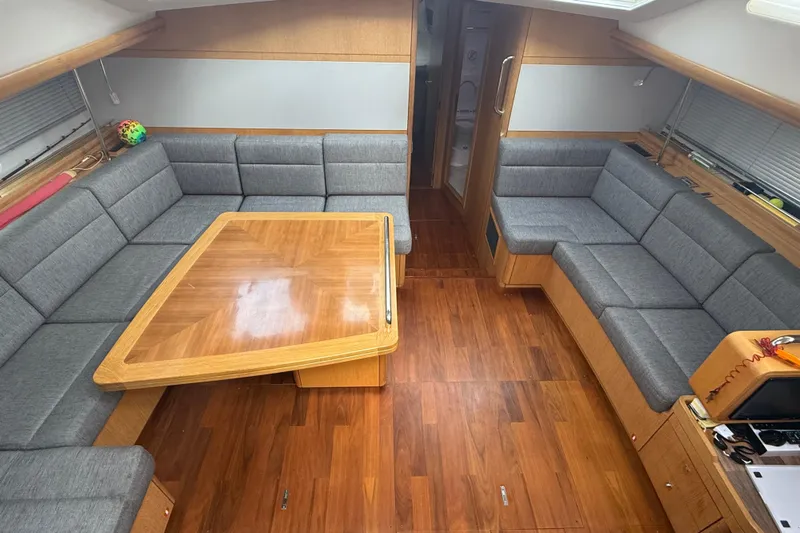 Tashatoo III Yacht Photos Pics Spacious interior of 2013 Gunfleet 58 yacht with wooden flooring and gray seating.