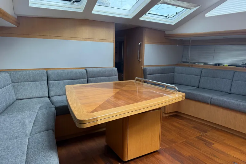 Tashatoo III Yacht Photos Pics Luxurious interior of 2013 Gunfleet 58 yacht with wooden table and gray seating.