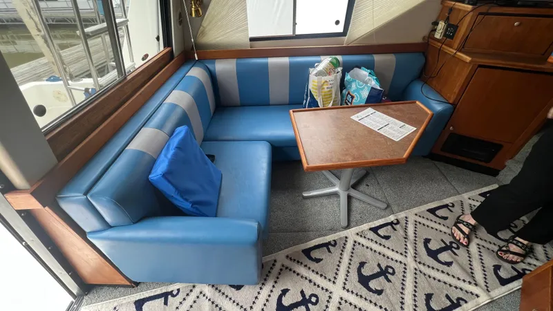  Yacht Photos Pics Interior of 1999 Bayliner 3988 Motoryacht with blue seating and wooden table.