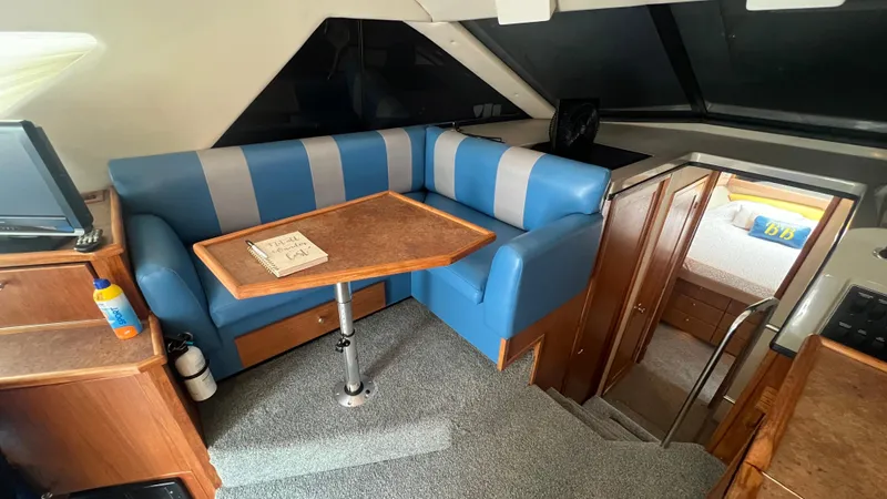  Yacht Photos Pics Interior of 1999 Bayliner 3988 Motoryacht with blue seating and wooden table.