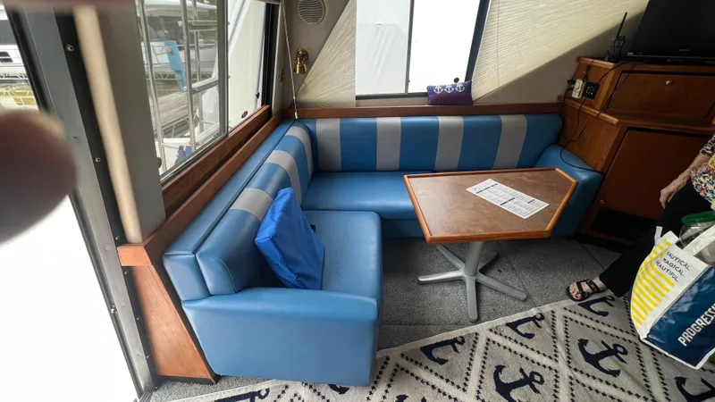  Yacht Photos Pics Interior of 1999 Bayliner 3988 Motoryacht with blue seating and wooden table.