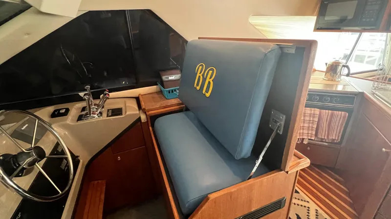  Yacht Photos Pics Interior of 1999 Bayliner 3988 Motoryacht with helm, blue seat, and kitchen area.