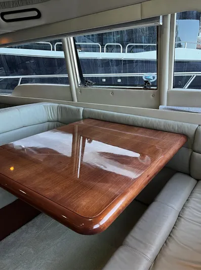  Yacht Photos Pics Interior of 2002 Sea Ray 56 Sedan Bridge with polished wooden table and leather seating.