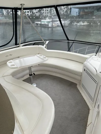  Yacht Photos Pics 2002 Sea Ray 56 Sedan Bridge interior with curved seating and table, overlooking marina.