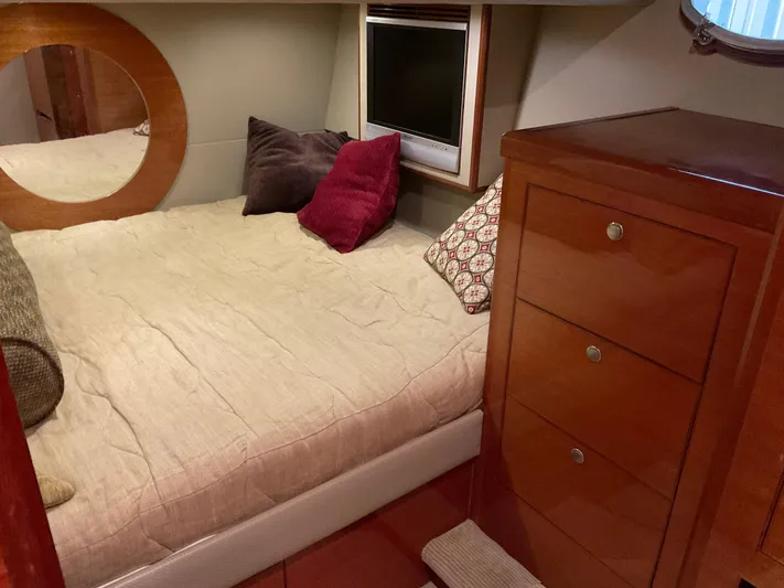  Yacht Photos Pics Cozy bedroom in 2007 Ocean Alexander 54V yacht with wooden cabinetry and plush bedding.