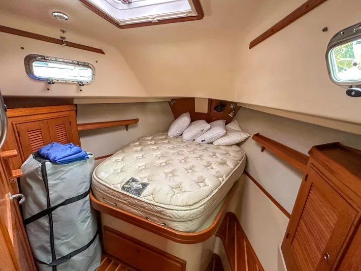 Three Dolphins Yacht Photos Pics Cozy cabin interior of 2005 Island Packet 370 sailboat with bed and storage.