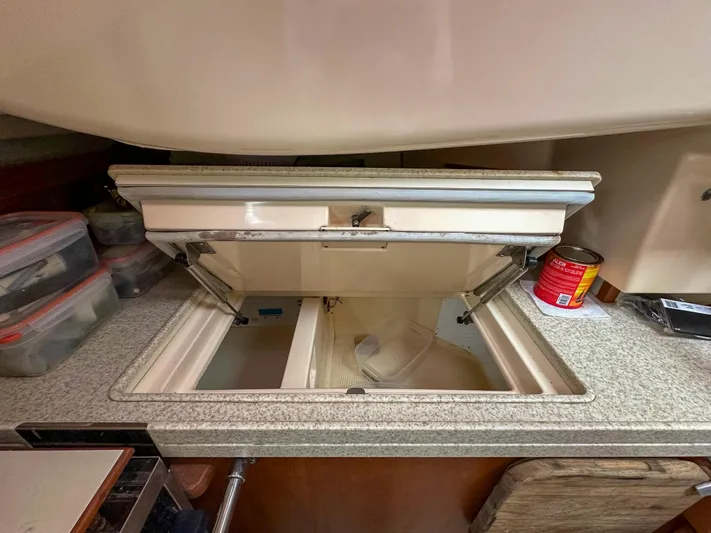 Three Dolphins Yacht Photos Pics Open storage compartment in 2005 Island Packet 370 yacht kitchen with organized containers.