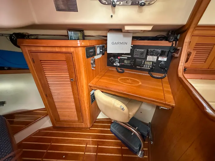 Three Dolphins Yacht Photos Pics Navigation station inside 2005 Island Packet 370 sailboat with Garmin equipment and wooden cabinetry.