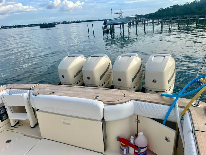  Yacht Photos Pics 2020 Scout 420 LXF boat with four powerful outboard engines on a serene waterfront.