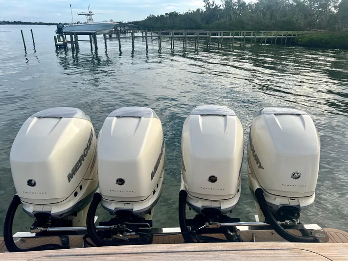  Yacht Photos Pics 2020 Scout 420 LXF with four Mercury outboard engines docked by a pier.