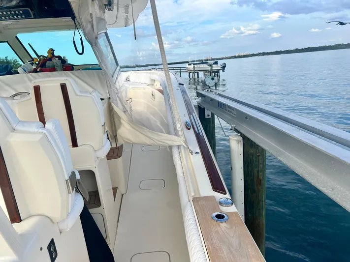  Yacht Photos Pics 2020 Scout 420 LXF boat docked by calm waters under a blue sky.