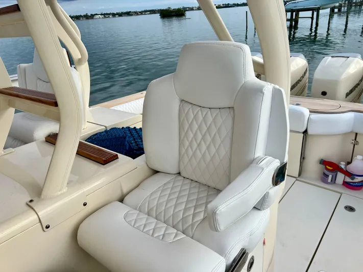  Yacht Photos Pics Luxurious white leather seat on 2020 Scout 420 LXF boat, docked by calm waters.