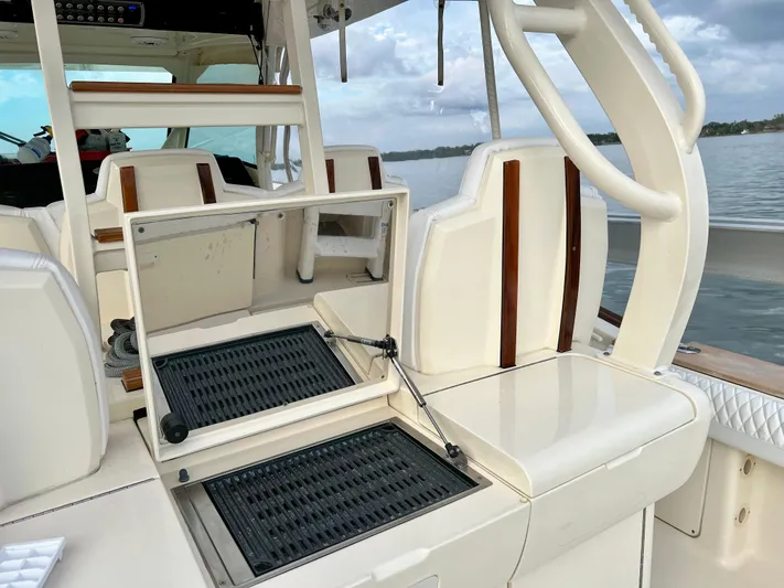  Yacht Photos Pics 2020 Scout 420 LXF boat interior with open storage compartment, white seating, and wood accents.