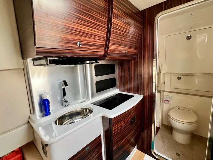  Yacht Photos Pics Luxurious 2020 Scout 420 LXF yacht interior with modern kitchenette and compact bathroom.