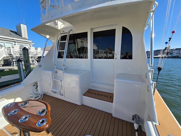  Yacht Photos Pics 2000 Post 47 Convertible yacht with wooden deck and ladder, docked by waterfront homes.