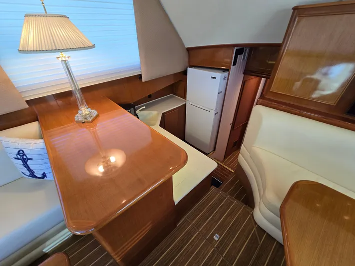  Yacht Photos Pics Interior of a 2000 Post 47 Convertible yacht with wooden furnishings and a cozy dining area.