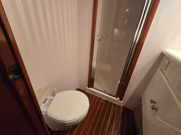  Yacht Photos Pics Bathroom with shower in 2000 Post 47 Convertible yacht, featuring wood flooring and compact design.
