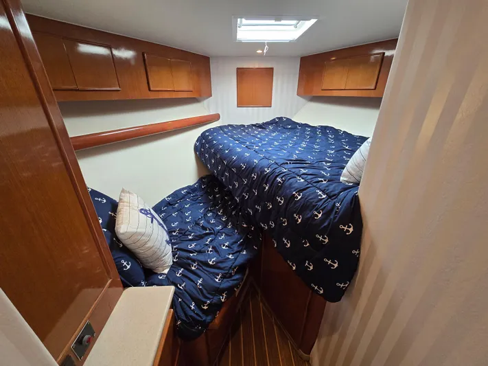  Yacht Photos Pics Cozy cabin interior of 2000 Post 47 Convertible with nautical-themed bedding.
