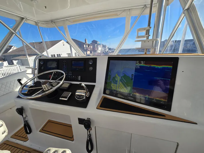 Yacht Photos Pics Helm of 2000 Post 47 Convertible yacht with navigation screens and steering wheel.